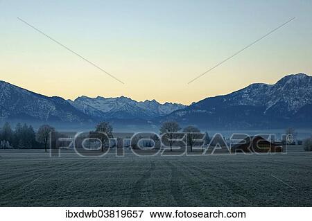 Stock Photo - "Sunrise on a frosty day with fog over the marshes of Benediktbeuren, Loisachtal Valley, Upper Bavaria, Bavaria, Germany, Europe". Fotosearch