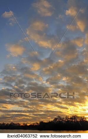 "Sunrise with clouds at the lake in Menzelen, North Rhine-Westphalia, Germany, Europe" View Large Photo Image Stock Image - "Sunrise with clouds at the lake in Menzelen, North Rhine-Westphalia, Germany, Europe". Fotosearch