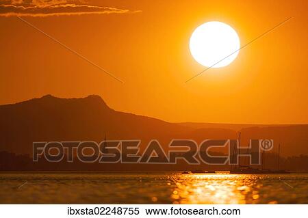 "Sunset on Lake Constance with a view of Radolfzell with Mt Hohenstoffeln, Baden-Wuerttemberg, Germany, Europe, PublicGround, Europe" View Large Photo Image Stock Photography - "Sunset on Lake Constance with a view of Radolfzell with Mt Hohenstoffeln, Baden-Wuerttemberg, Germany, Europe, PublicGround, Europe". Fotosearch
