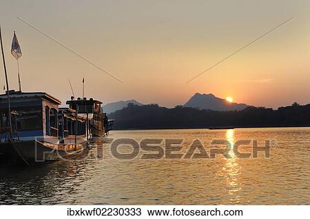 Stock Image - "Sunset on the Mekong river, Luang Prabang, Laos, Southeast Asia, Asia". Fotosearch