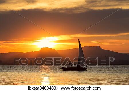 "Sunset, sailboat on Lake Constance, in the back Hohentwiel and Hohenstoffel, Reichenau island, Lake Constance, Baden-Wurttemberg, Germany, Europe" View Large Photo Image Stock Photo - "Sunset, sailboat on Lake Constance, in the back Hohentwiel and Hohenstoffel, Reichenau island, Lake Constance, Baden-Wurttemberg, Germany, Europe". Fotosearch