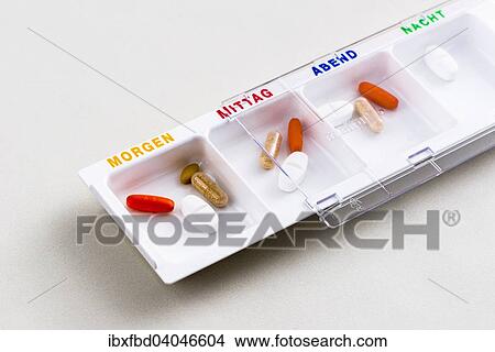 "Tablet dispenser filled with pills for the whole day, labelled in German" View Large Photo Image Picture - "Tablet dispenser filled with pills for the whole day, labelled in German". Fotosearch