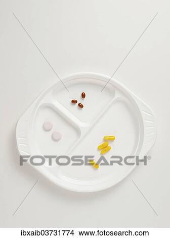 Picture - "Tablets, food supplements on a plastic plate". Fotosearch