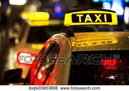Stock Photo - "Taxi in the rain at night, Cologne, North Rhine-Westphalia, Germany, Europe". Fotosearch