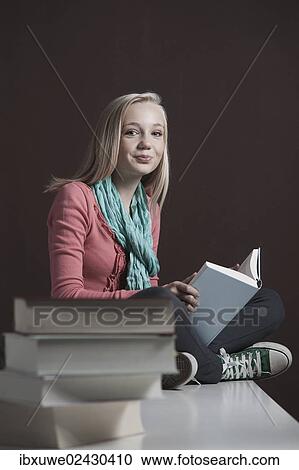 "Teenage girl reading a book, with a pile of books at the front" View Large Photo Image Stock Image - "Teenage girl reading a book, with a pile of books at the front". Fotosearch