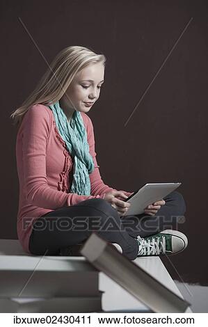 "Teenage girl with a digital tablet, with a pile of books at the front" View Large Photo Image Stock Image - "Teenage girl with a digital tablet, with a pile of books at the front". Fotosearch
