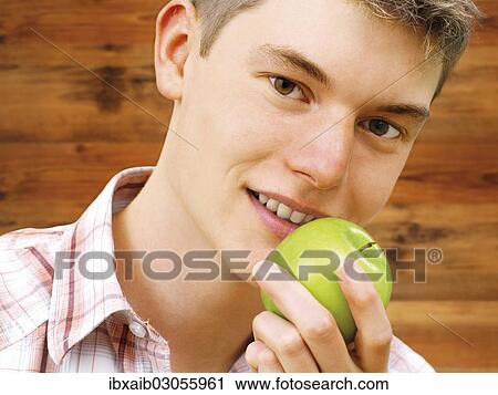 Teenager holding a green apple View Large Photo Image Stock Image - Teenager holding a green apple. Fotosearch