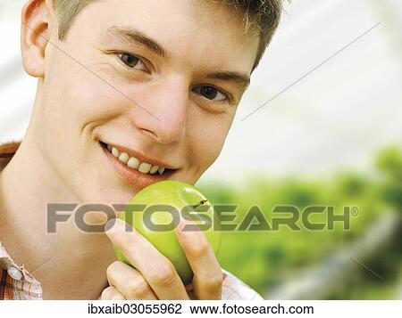 Teenager holding a green apple View Large Photo Image Stock Image - Teenager holding a green apple. Fotosearch