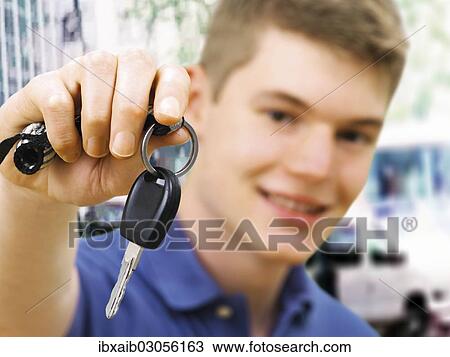 Stock Image - Teenager holding car keys after passing a driving test. Fotosearch