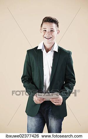 "Teenager in a formal jacket, holding a digital tablet" View Large Photo Image Stock Photograph - "Teenager in a formal jacket, holding a digital tablet". Fotosearch