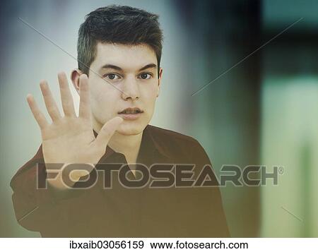 Teenager making a defensive gesture with a raised hand View Large Photo Image Stock Photo - Teenager making a defensive gesture with a raised hand. Fotosearch