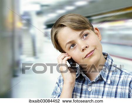 Teenager using a mobile phone in an underground railway station View Large Photo Image Stock Image - Teenager using a mobile phone in an underground railway station. Fotosearch