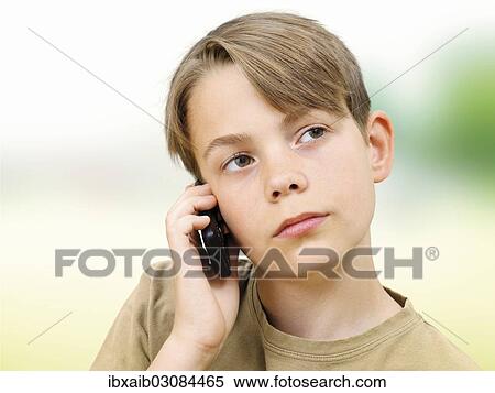 Stock Photography - "Teenager using a mobile phone, serious, concentrating". Fotosearch