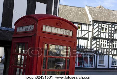 Stock Image - "Telephone booth or phone box in the historical town of Newent, characterized by half-timbered buildings, Gloucestershire, England, United Kingdom, Europe". Fotosearch