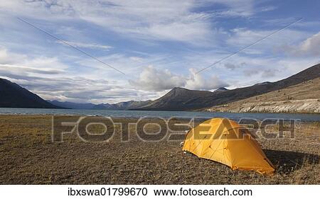 Stock Image - "Tent on the shore of Kusawa Lake, mountains behind, Yukon Territory, Canada, North America". Fotosearch