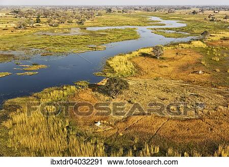 Stock Image - "The Gomoti River with its adjoining freshwater marshland, aerial view, Okavango Delta, Botswana, Africa". Fotosearch