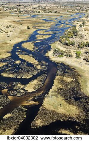 Stock Image - "The Gomoti River with its channels, islands, sandbanks and adjoining freshwater marshland, aerial view, Okavango Delta, Botswana, Africa". Fotosearch