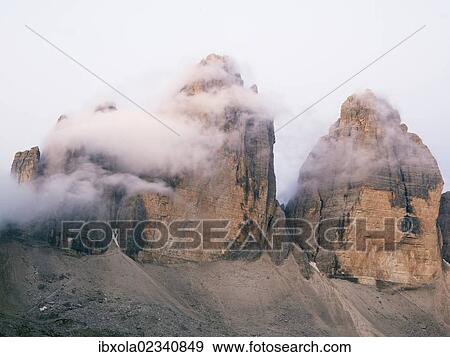 Stock Photo - "The peaks of Tre Cime di Lavaredo in clouds at dawn, Dolomiti di Sesto National Park, Sexten Dolomites, Hochpustertal, High Puster Valley, South Tyrol, Italy, Europe". Fotosearch