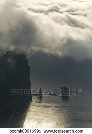 "The Risin og Kellingin sea stacks and the Eioiskollur cliff in evening light, at Eioi, Eysturoys, Faroe Islands, Denmark, Europe" View Large Photo Image Stock Photography - "The Risin og Kellingin sea stacks and the Eioiskollur cliff in evening light, at Eioi, Eysturoys, Faroe Islands, Denmark, Europe". Fotosearch