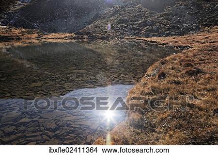 "The sun being reflected on Lake Lindersee near Zirbitzkogel mountain, Seetal Alps, Styria, Austria, Europe" View Large Photo Image Picture - "The sun being reflected on Lake Lindersee near Zirbitzkogel mountain, Seetal Alps, Styria, Austria, Europe". Fotosearch
