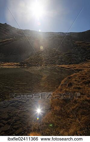 "The sun being reflected on Lake Lindersee near Zirbitzkogel mountain, Seetal Alps, Styria, Austria, Europe" View Large Photo Image Stock Photograph - "The sun being reflected on Lake Lindersee near Zirbitzkogel mountain, Seetal Alps, Styria, Austria, Europe". Fotosearch