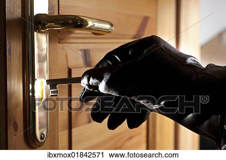 Thief trying to open a door with a key View Large Photo Image Stock Image - Thief trying to open a door with a key. Fotosearch