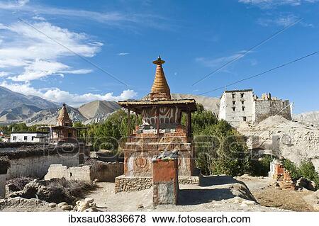 Stock Photo - "Tibetan Buddhism, colorful stupa, the old Royal Palace at the back, white ruins, Dzong architecture, Charang, Mustang District, Nepal, Asia". Fotosearch