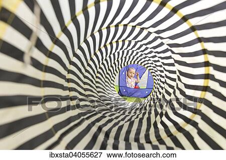 "Toddler, 18 months, playing in the garden, viewed through a play tunnel" View Large Photo Image Stock Photo - "Toddler, 18 months, playing in the garden, viewed through a play tunnel". Fotosearch