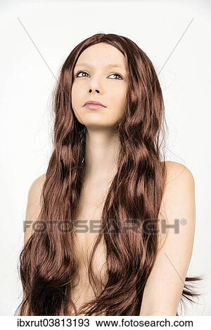 Stock Image - Topless woman wearing a wig with long hair. Fotosearch