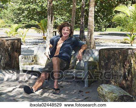 "Tourist, 48 years, relaxing on a bench on the promenade of Playa Carryllo, Nicoya Peninsula, Costa Rica, Central America, North America" View Large Photo Image Stock Photo - "Tourist, 48 years, relaxing on a bench on the promenade of Playa Carryllo, Nicoya Peninsula, Costa Rica, Central America, North America". Fotosearch