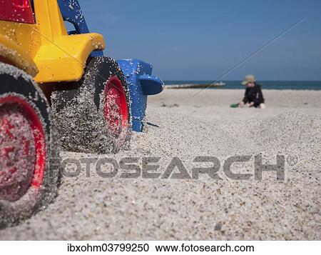 "Toy digger on a beach, child at the back, Mecklenburg-Western Pomerania, Germany, Europe" View Large Photo Image Stock Image - "Toy digger on a beach, child at the back, Mecklenburg-Western Pomerania, Germany, Europe". Fotosearch