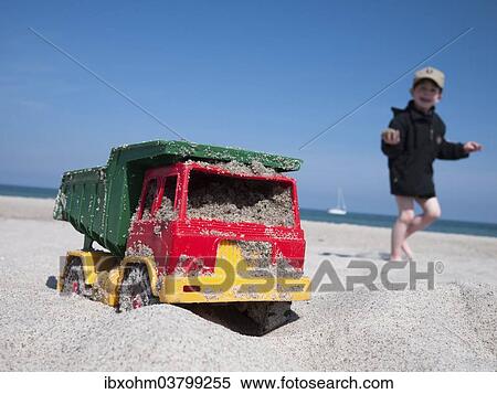 "Toy dumper truck on a beach, boy at the back, Mecklenburg-Western Pomerania, Germany, Europe" View Large Photo Image Stock Photography - "Toy dumper truck on a beach, boy at the back, Mecklenburg-Western Pomerania, Germany, Europe". Fotosearch