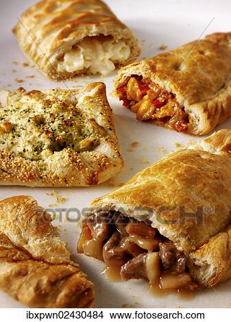 Picture - "Traditional Cornish pasties or pastys, cheese pie, chicken tikka and onion pie and cheese pies, from scratch". Fotosearch