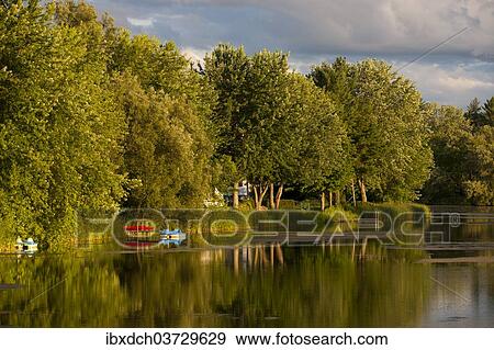 "Trees and boats on Yamaska River in evening light with threatening clouds, Waterloo, Eastern Townships, Quebec Province, Canada, North America" View Large Photo Image Stock Photo - "Trees and boats on Yamaska River in evening light with threatening clouds, Waterloo, Eastern Townships, Quebec Province, Canada, North America". Fotosearch