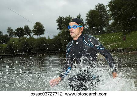 "Triathlete running through water, Aichstruter Reservoir, Welzheim, Baden-Wurttemberg, Germany, Europe" View Large Photo Image Stock Image - "Triathlete running through water, Aichstruter Reservoir, Welzheim, Baden-Wurttemberg, Germany, Europe". Fotosearch