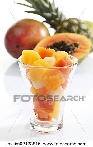 Stock Photograph - "Tropical fruit from a tin can presented in a glass, pineapple, papaya, mango". Fotosearch
