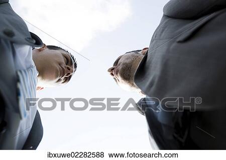 Stock Photo - Two businessmen staring angrily at each other. Fotosearch