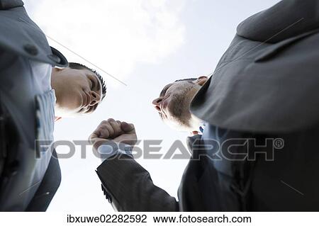 Stock Image - Two businessmen threatening each other. Fotosearch