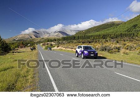 Stock Image - "Two cars driving on a country road, driving on the left, Arthur's Pass Road, South Island, New Zealand, Oceania". Fotosearch
