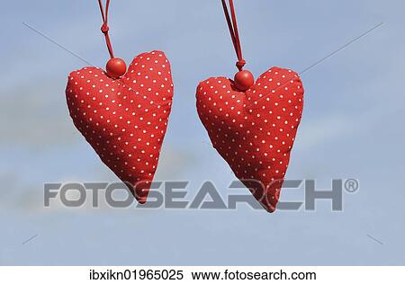 Stock Photography - Two fabric hearts against a blue sky. Fotosearch