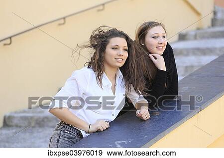 "Two girlfriends, teenagers, leaning on the railing of a staircase, looking into the distance, Menton, Alpes-Maritimes, Provence-Alpes-Cote d'Azur, France, Europe" View Large Photo Image Stock Photo - "Two girlfriends, teenagers, leaning on the railing of a staircase, looking into the distance, Menton, Alpes-Maritimes, Provence-Alpes-Cote d'Azur, France, Europe". Fotosearch