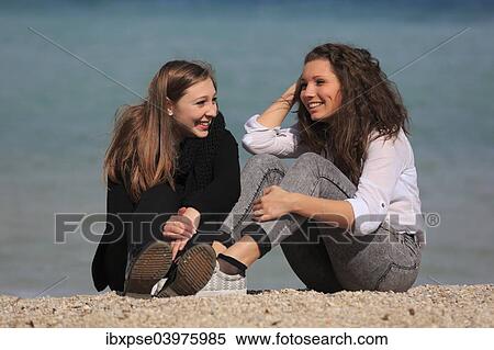 "Two girlfriends, teenagers, sitting on the beach, Menton, Alpes-Maritimes, Provence Alpes, France, Europe" View Large Photo Image Stock Photography - "Two girlfriends, teenagers, sitting on the beach, Menton, Alpes-Maritimes, Provence Alpes, France, Europe". Fotosearch