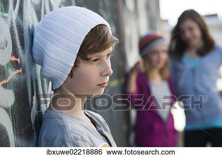 Stock Photograph - Two girls making fun of a boy. Fotosearch