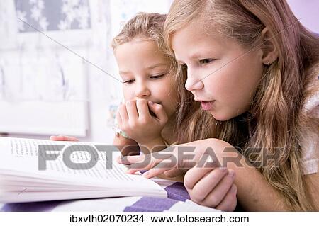 "Two girls, sisters reading in bed" View Large Photo Image Picture - "Two girls, sisters reading in bed". Fotosearch