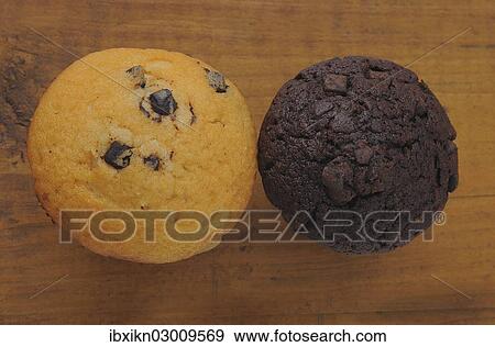 Two muffins on an old wooden board View Large Photo Image Stock Photo - Two muffins on an old wooden board. Fotosearch