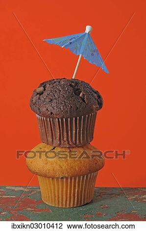 "Two muffins, stacked, with an umbrella" View Large Photo Image Stock Image - "Two muffins, stacked, with an umbrella". Fotosearch