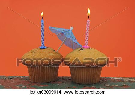 Two muffins with birthday candles and an umbrella View Large Photo Image Picture - Two muffins with birthday candles and an umbrella. Fotosearch
