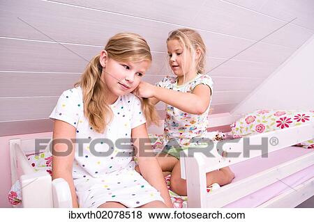 "Two sisters in bed, doing their hair" View Large Photo Image Stock Photo - "Two sisters in bed, doing their hair". Fotosearch