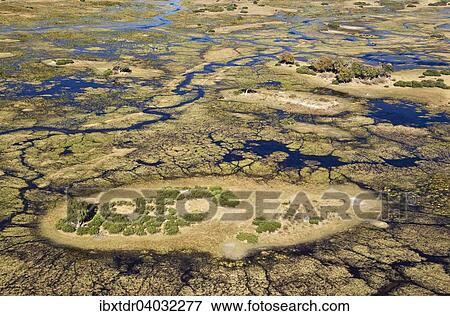Stock Photo - "Typical landscape of freshwater marshes with streams, channels and islands, aerial view, Okavango Delta, Botswana, Africa". Fotosearch