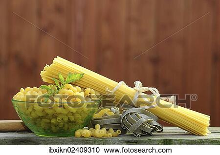 Stock Image - Various types of pasta with a glass bowl. Fotosearch
